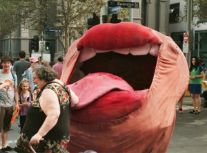 Huge Snuff Puppet Mouth licks woman in the street.