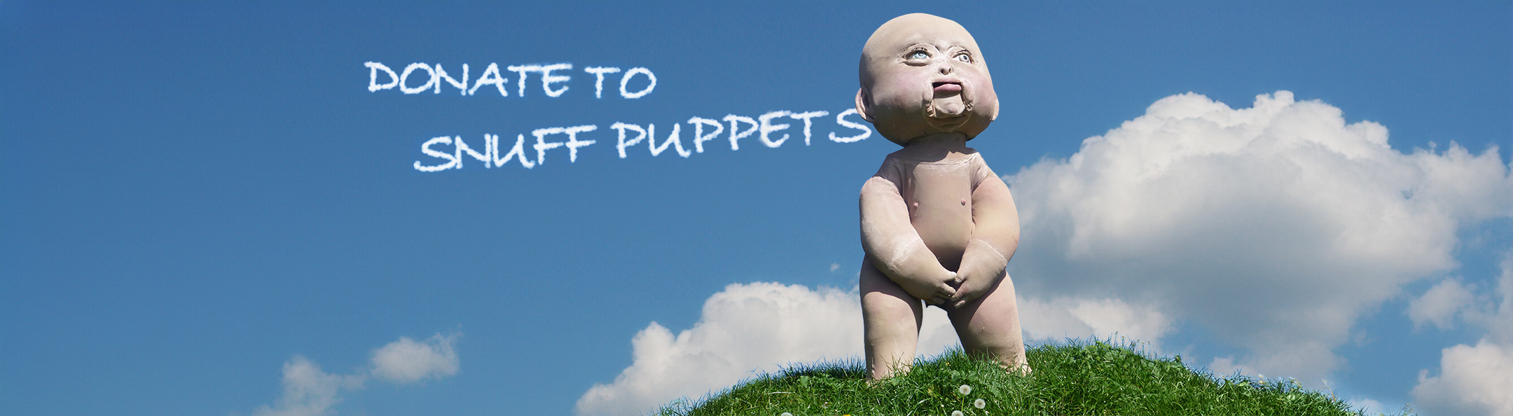 Photo of seven foot tall Baby puppet standing on grass on a hill
