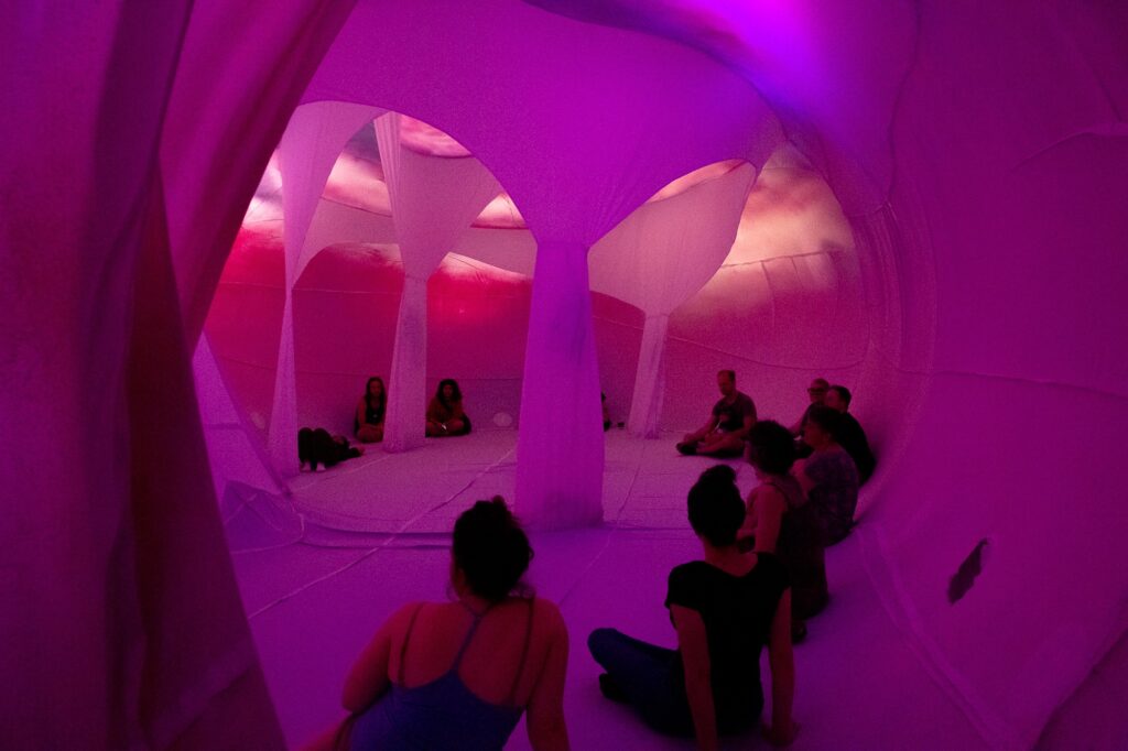 ten people sit inside a large pink inflatable